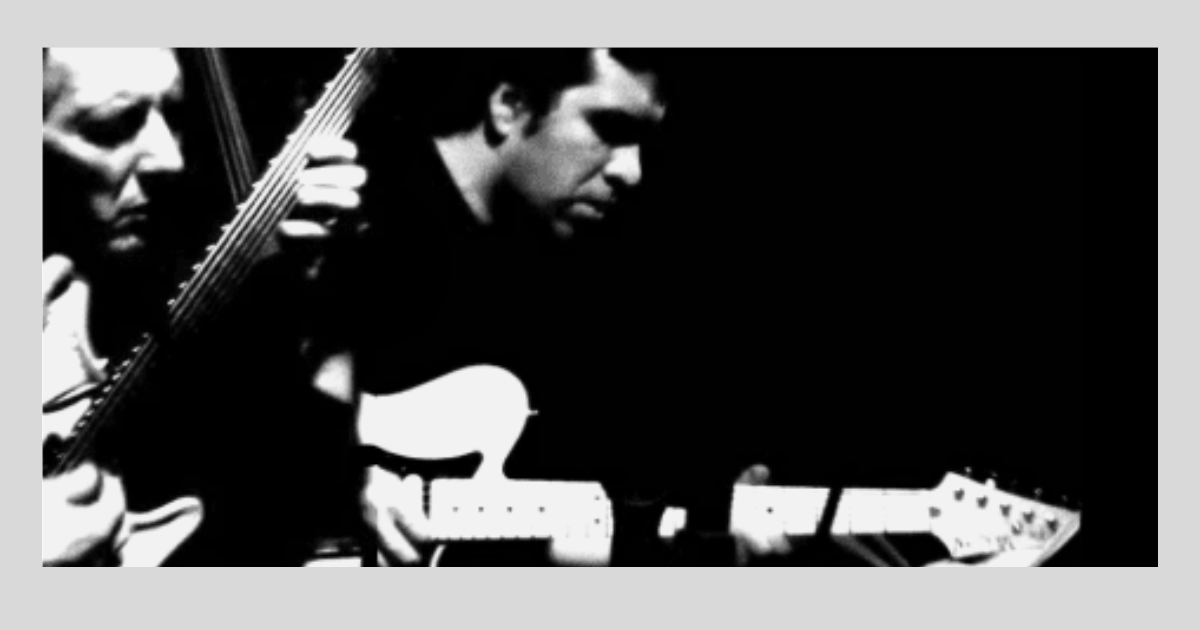 German Herlein playing guitar with John Stowell, black and white photo